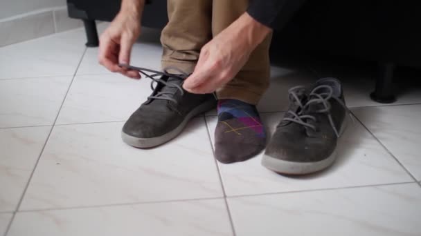 白种人把他的鞋子绑在白瓷砖地板上 — 图库视频影像