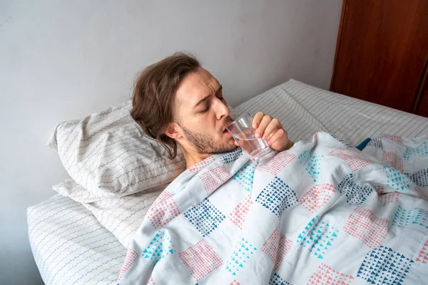 Joven Caucásico Masculino Agua Potable Cama — Foto de Stock