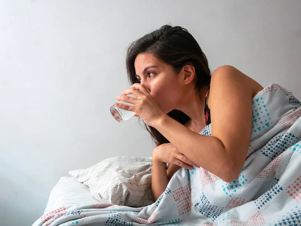 Joven Morena Cabello Hispano Mujer Bebiendo Agua Cama — Foto de Stock