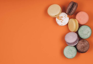 Mercan ya da turuncu arka planda geleneksel Fransız makaronu seti. Tatlı tatlı.