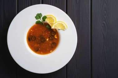 Ev yapımı Rus çorbası - solyanka. Akşam yemeği. Et soslu sebze yemeği. Siyah arkaplanda restoran tarifi menüsü