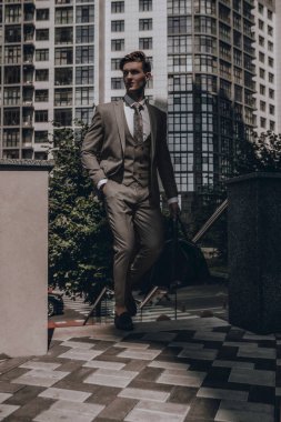Şehirde poz veren klasik takım elbiseli yakışıklı sakallı işadamı. Şık genç erkek model portre. Klasik tarz