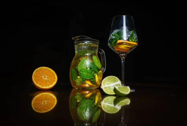 Tea on a black background. Fruit tea. Cold tea. Teapot with tea.