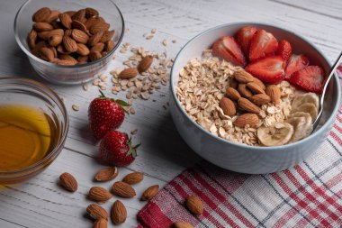 Böğürtlenli yulaf ezmesi, fındık, beyaz arka planda bal. Sağlıklı kahvaltı. Vejetaryen yemeği.
