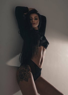 İç çamaşırı ve spor ayakkabılarıyla esmer saçlı çekici seksi moda kadını. Stüdyoda siyah arka planda baştan çıkarıcı seksi kadın modelinin portresi.
