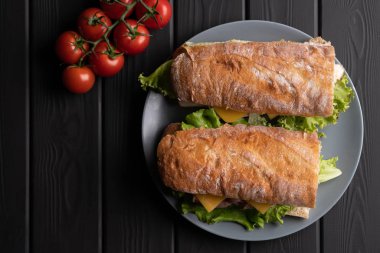 Tahta arka planda domatesli baget sandviç. Mutfağa. Lezzetli ekmek. Yiyecekler. Üst görünüm