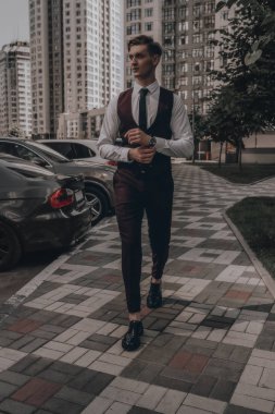İş konsepti. Şehir manzarasında takım elbiseli yakışıklı bir işadamı. Genç manken. Başarı yaşam tarzı
