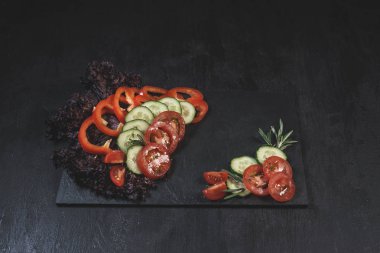 Pişirmek için ham malzemeler. Domates, salatalık, biber, otlar, baharatlar, masada zeytinyağı. Yemek pişirmek için hazır. Üst görünüm arkaplanı. Mesaj için yer var. Sağlıklı beslenme. Yemek pişirme konsepti. 