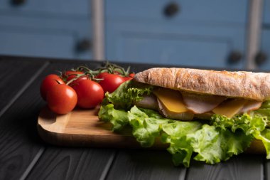 Sebzeli ve peynirli farklı sandviçler. Taze baget. Kahvaltıda. Siyah masa. Mutfak.