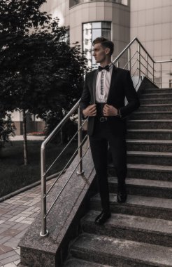 Şehir caddesinde poz veren genç yakışıklı iş adamı. Başarı yaşam tarzı. İş konsepti