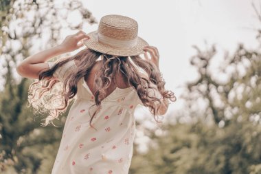 Gün batımında bahçedeki güzel kızın arka plan portresi. Neşeli, gülümseyen çocuk portresi..