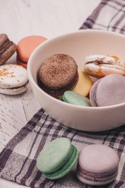 Beyaz masa arkaplanındaki renkli makaron setini kapat. Geleneksel Fransız tatlısı. Tatlı lezzetli yemekler.