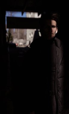 Yüzünün yarısını kaplayan gölgesi olan yakışıklı bir genç adamın portresi