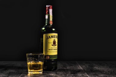 Kiev, Ukrayna - 07 Kasım 2018. Jameson viski şişesi ve siyah zemin üzerinde buz küpleri olan cam. Jameson, Dublin 'den gelen geleneksel İrlanda viskisi markasıdır.
