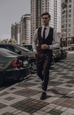 Sokak arka planında poz veren modaya uygun genç iş adamı. Zarif yakışıklı manken portresi. Klasik tarz konsept. Başarı. Finans müdürü. Şirket işi