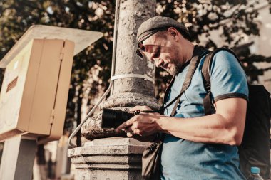 Erkek fotoğrafçı. Gezgin turist. Paparazziler. Yetişkin erkek, sokak manzarasına bakıyor. Bağımsız çalış. Gazeteci haberi. - Dedektif. Hobi.