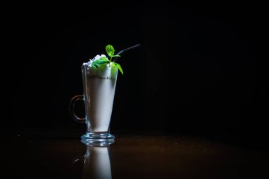 Siyah arka planda kahve içiyorlar. Siyah bir masada kahve. Soğuk kahve. Sütlü. Kapuçino. Espresso. Kahve kokteylleri. Milkshakeler. Krem şanti. Barista. 