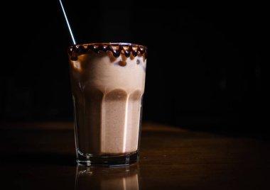 Siyah arka planda kahve içiyorlar. Siyah bir masada kahve. Soğuk kahve. Sütlü. Kapuçino. Espresso. Kahve kokteylleri. Milkshakeler. Krem şanti. Barista. 