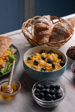 Geleneksel lezzetli kahvaltı. Mısır gevreği, tahıl ekmeği, kruvasan, taze yiyecek. Günaydın Neal. Mutfak.