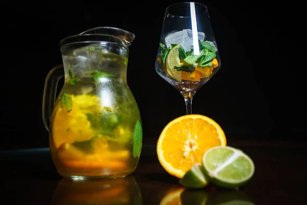 Tea on a black background. Fruit tea. Cold tea. Teapot with tea.