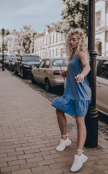 Girl street style. Fashion young beautiful woman posing on city street. Urban. Sundress. Lifestyle. Moment. Holidays. Summer time