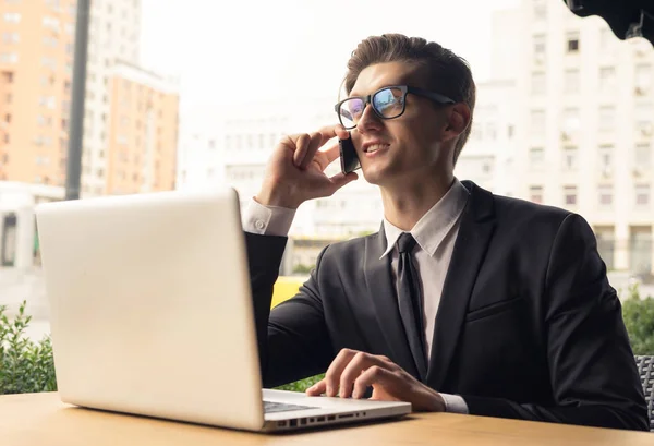 Smiling Young Businessman Talking Cellphone Looking Laptop — Stok Foto