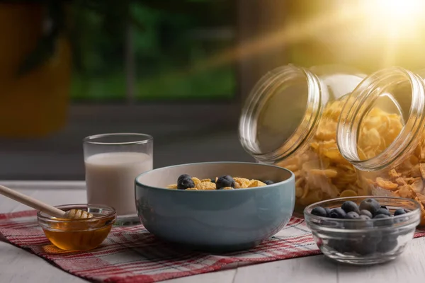 Cereal flakes. Corn flakes with berry and honey. Breakfast. Kitchen. Healthy food. Wooden table. Window