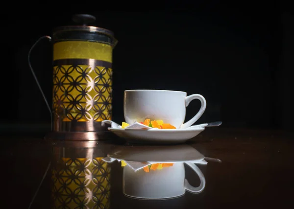 Tea on a black background. Fruit tea. Cold tea. Teapot with tea.