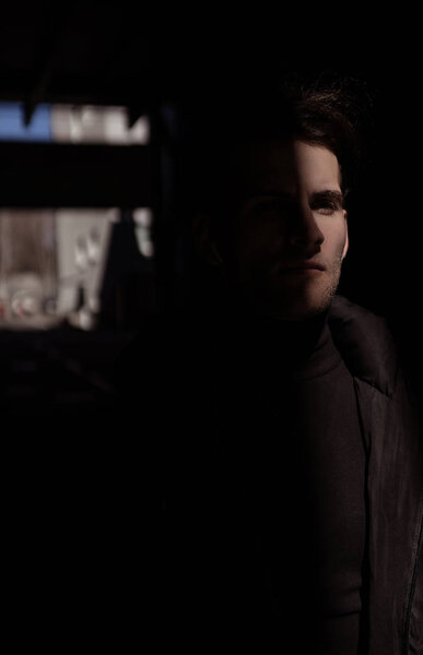 Молодой человек позирует в модном наряде на городском фоне
