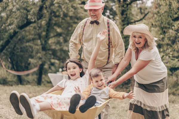 Abuelos Parque Con Nietos Jugando Con Carro Familia Divertirse Jardín Fotos de stock libres de derechos