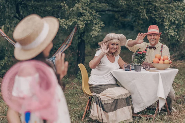 Nonna Nonno Felici Sono Seduti Tavola Bevendo Limonata Agitando Mani Foto Stock