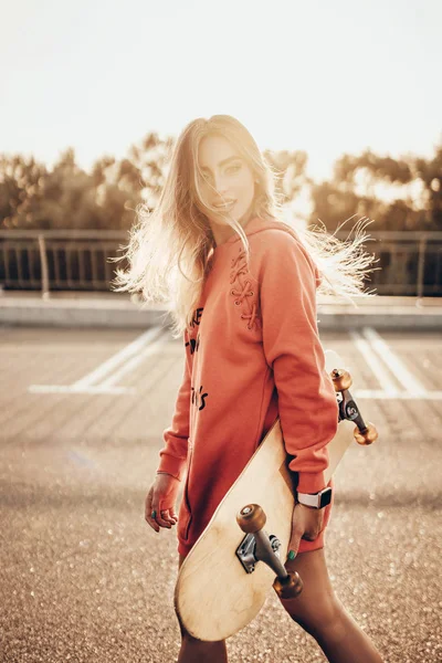 Gadis Cantik Bergaya Perkotaan Dengan Hoodie Merah Dan Skateboard Berjalan — Stok Foto