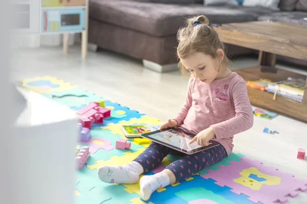 Cute Little Girl Using Digital Tablet Sitting Floor Home Middle Royalty Free Stock Photos