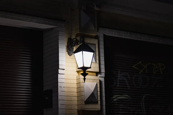 Nacht Stadt Laterne leuchten an Wand aus nächster Nähe Stockbild