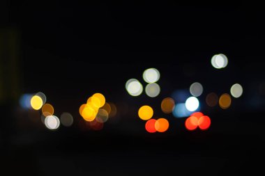 Şehirdeki Bokeh ışıklarının soyut görüntüsü. Beyaz, kırmızı, turuncu