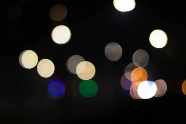 Imagem abstrata do bokeh de luzes verdes azuis amarelas na cidade — Fotografia de Stock