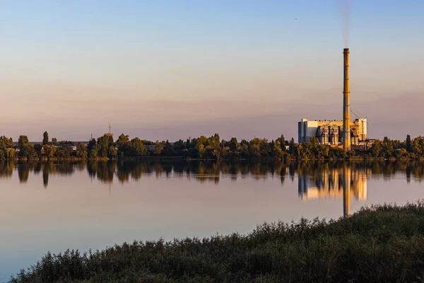 Old waste processing plant at the lake sunset