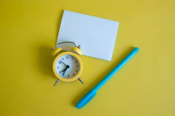 Reloj Despertador Amarillo Hoja Blanca Blanco Pluma Azul Vista Superior —  Fotos de Stock