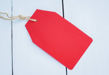 Giysiler için kırmızı kağıt etiket beyaz ahşap arkaplanı kapat