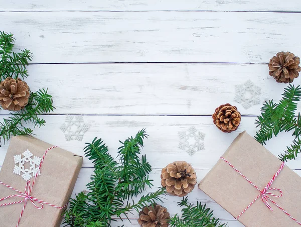Noel Arkaplanı Kozalaklar Hediye Kutuları Kozalaklı Ağaçların Beyaz Tahta Dalları — Stok fotoğraf
