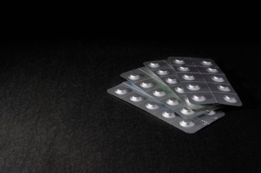 Tıbbi antibiyotikler, haplar, siyah arka planda antibakteriyel haplar.