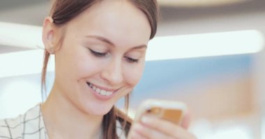 İş kadını portresi. Ortak Çalışma Alanında Akıllı Telefon Kullanıyor. Yakın plan. 4K Yavaşlama Hareketi, DCI. Modern cam binada cep telefonu kullanan çekici bir kadın. İletişim ve Teknoloji