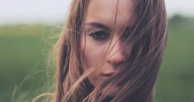 Rüzgarda Ayakta Duran Kadın Portresi. Yavaş hareket et. 4K DCI. Breeze kız saçıyla oynuyor. Fırtınalı hava, sonbahar, kış, bahar.