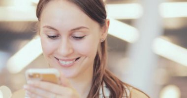 İş kadını portresi. Ortak Çalışma Alanında Akıllı Telefon Kullanıyor. Yakın plan. 4K Yavaşlama Hareketi, DCI. Modern cam binada cep telefonu kullanan çekici bir kadın. İletişim ve Teknoloji