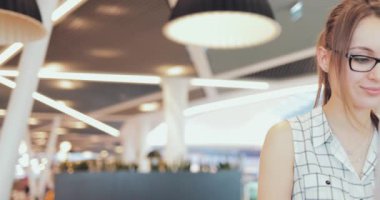 İş kadını portresi birlikte çalışma alanında dizüstü bilgisayarda çalışıyor. 4K Yavaşlama Hareketi, DCI. Genç bir iş kadını, gözlük takıyor, modern ofis binasında taşınabilir bilgisayar kullanıyor. Hayatta Teknoloji