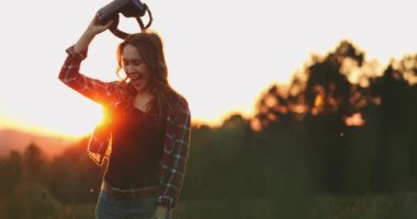 Sanal Gerçeklik Gözlüklü Kadın Tezahürat Yapıyor. Yavaş haraket 4K. Sanal 3 boyutlu dünyanın tadını çıkaran, VR kulaklıkla oynayan neşeli genç bir kadın. Güneşli alan arkaplanı, hayali gerçekliğin içinde.