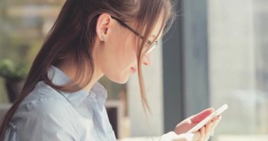 Kadın Elleri Kafede Akıllı Telefon Kullanıyor. Yavaş hareket, dengeleyici. İş kadını bir kafede sosyal medyada mesajlaşıyor, iletişim kuruyor, internette çalışıyor, interneti arıyor, öğreniyor.