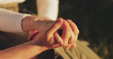İki Aşığın El ele tutuşması 'na yaklaş. Yavaş haraket 4K. Erkek ve kadın el ele tutuşuyor, sarılıyorlar. Çift Güven, Aşk ve Mutluluk konsepti. Aile bakımı.