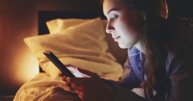 Geceleri Tablet Bilgisayar kullanan bir kadın. Yavaş hareket et. 4K DCI. Genç milenyum tüketicisi evden online alışveriş yapıyor, yatakta yatıyor. Günlük yaşamda teknoloji.
