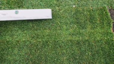 Çimenlik Yuvarlayan Adam. Çim yapıyorum. Yavaş bir hareket yap. Tanımlanamayan bahçıvan elleri yeşil çimlerden mükemmel bir çim oluşturuyor. Peyzaj tasarımı üzerinde çalışan kişi.